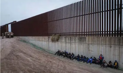  ?? Penitas, Texas. Photograph: Adrees Latif/Reuters ?? The Texas army national guard stand in the background as asylum-seeking migrants from Central America line up near the border in