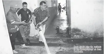  ??  ?? Hasbi (right) joins the residents in the ‘gotong-royong’ at Desa Pabahanan.