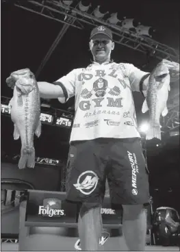  ?? Arkansas Democrat-Gazette/BRYAN HENDRICKS ?? Rogers’ Travis Fox caught five bass weighing 14 pounds, 9 ounces Saturday to move into third place entering today’s championsh­ip round at the FLW Tour event on Beaver Lake. Today’s winner collects $125,000.