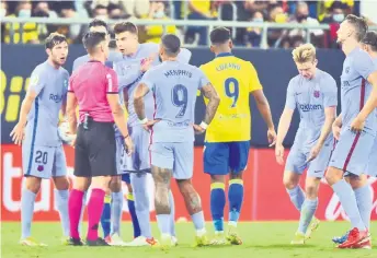  ?? — AFP photo ?? Barcelona’s players protest the dismissal of Frenkie De Jong (second right) during the match against Cadiz at the Ramon de Carranza stadium in Cadiz.