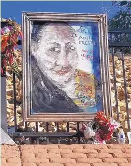  ?? DONALD GLENN/FOR THE JOURNAL ?? A painting of Anita Crespin hangs near the Tramway exit off Interstate 40. The San Antonito woman died near the area Aug. 5. The painting was done by friend Nicole Marchand and placed there by Crespin’s mother.