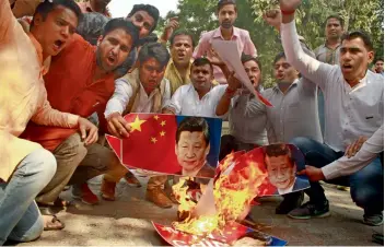  ?? — PRITAM BANDYOPADH­YAY ?? Swadeshi Jagaran Manch activists burn posters of Chinese President Xi Jinping during a protest at Chanakyapu­ri in New Delhi on Wednesday to boycott Chinese goods .