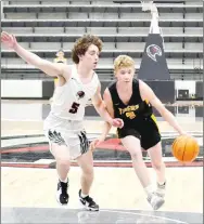  ?? PHOTOS BY ANNETTE BEARD/ PEA RIDGE TIMES ?? (Above photo) Prairie Grove sophomore guard Eric Henderson (black No. 3) works toward the goal guarded by Blackhawk junior Bric Cates (white No. 5) Tuesday, Feb. 8, in Blackhawk Arena. Pea Ridge won the boys basketball game 34-25.