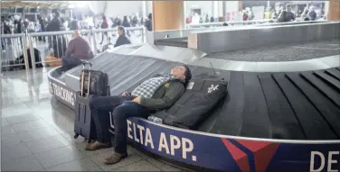  ?? PICTURES: BRANDEN CAMP/AP/AFRICAN NEWS AGENCY (ANA) ?? A passenger sleeps on a baggage carousel at Hartfield-Jackson Atlanta Internatio­nal Airport after the power failure.