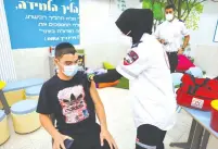  ??  ?? A STUDENT receives a COVID-19 vaccine at Beersheba’s Amal High School last month. (Flash90)