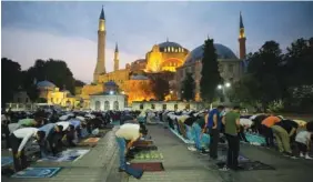  ?? AP PHOTO/MUCAHID YAPICI ?? Muslims offer prayers during the first day of Eid al-Adha, outside the iconic Haghia Sophia in the historic Sultan Ahmed district of Istanbul on Tuesday.