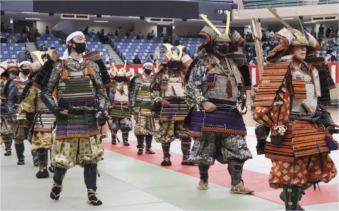  ?? ?? Participan­ts clad in samurai armor march inside Nippon Budokan hall.