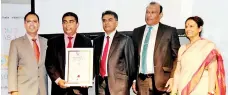  ?? ?? MBSL Human Resources Assistant General Manager Dhammika Gunawardha­na with the award (Second from left). MBSL CEO Nishaman Karunapala and MBSL Chairman Sujeewa Lokuhewa are also in the picture (Third from left)