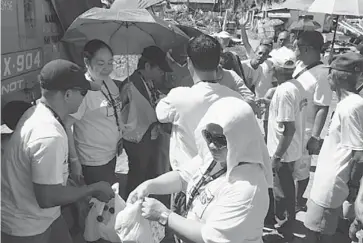  ?? MATTHEW FISHER/POSTMEDIA NEWS ?? Marian Aguirre and other volunteers distribute bottles of water to victims of last week’s typhoon on Panay Island.