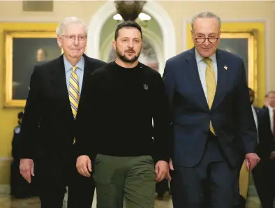  ?? DREW ANGERER/GETTY ?? Senate Minority Leader Mitch McConnell, R-Ky., from left, walks with Ukrainian President Volodymyr Zelenskyy and Senate Majority Leader Charles Schumer, D-N.Y., on Dec. 12 as Zelenskyy arrives at the U.S. Capitol to meet with congressio­nal leadership.