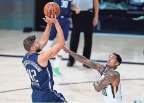  ?? ASHLEY LANDIS/POOL PHOTO/USA TODAY SPORTS ?? The Mavericks’ Maxi Kleber (42) shoots as the Jazz’s Jordan Clarkson (00) defends during the first half on Monday.