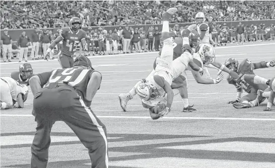  ?? Yi-Chin Lee / Houston Chronicle ?? Katy’s Deondrick Glass dives into the end zone late in the third quarter for the second of his two rushing touchdowns in the Tigers’ victory over North Shore.