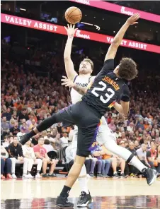  ?? — AFP photo against Cameron ?? Luka Doncic of the Dallas Mavericks attempts a shot Johnson of the Phoenix Suns.