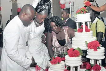  ?? PICTURE: AP ?? Dickson Torgbor Gbarjolo and Quoisey Korzu cut their cake at their wedding in Monrovia on Saturday. Many weddings have been postponed as Ebola ravages the capital, and Liberia has warned against large gatherings.