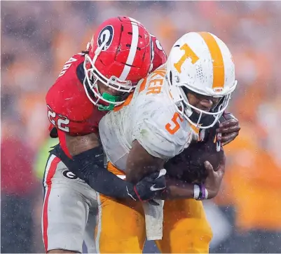  ?? GETTY IMAGES ?? Javon Bullard takes down Tennessee QB Hendon Hooker, one of six sacks by Georgia’s defense in the SEC showdown.