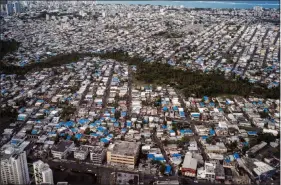  ?? TODD HEISLER / THE NEW YORK TIMES FILE (2018) ?? Damaged roofs are covered with blue tarps Feb. 2 in San Juan, Puerto Rico.