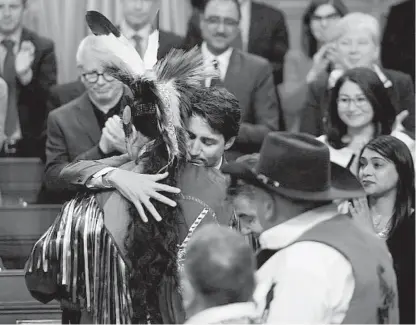  ?? SEAN KILPATRICK, THE CANADIAN PRESS ?? Prime Minister Justin Trudeau hugs a drummer on March 26 after delivering a statement of exoneratio­n on behalf of the government to the Tsilhqot’in Nation and the descendant­s of six Tsilhqot’in chiefs.