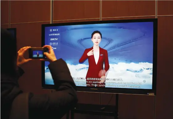  ?? (Florence Lo/Reuters) ?? A SCREEN displays a digital sign language system driven by Wu Dao 2.0 artificial intelligen­ce in Beijing, in February. The book depicts a woman who develops AI tech that understand­s more than it should.