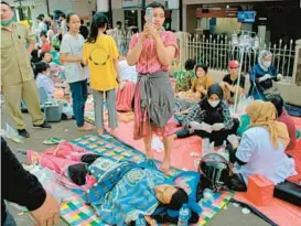  ?? KHOLID/AP ?? Earthquake survivors are treated outside of a hospital Monday in the town of Cianjur, part of a mountainou­s district of the same name with over 2.5 million people in Indonesia.