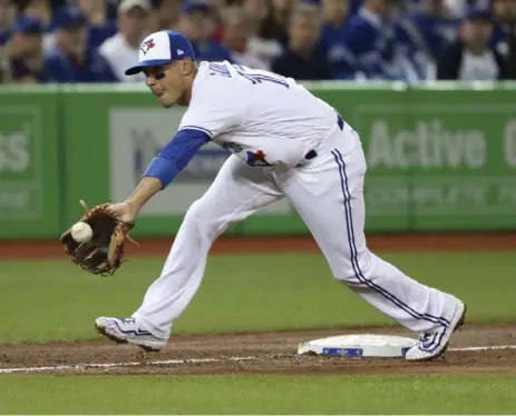  ?? RICHARD LAUTENS/TORONTO STAR ?? Jays infielder Ryan Goins showed off his defensive skills in the second inning, throwing out Milwaukee’s Jonathan Villar to end the frame.