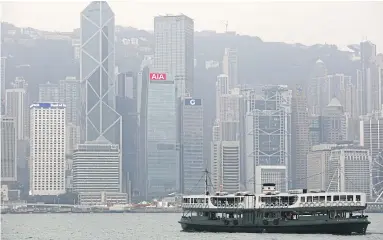  ??  ?? A ferry sails at Victoria Harbour in front of the financial Central district in Hong Kong. Prime office rents in the district are expected to jump 5-10% this year.