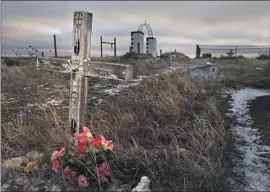  ?? Rapid City Journal ?? A GRAVE at Wounded Knee in South Dakota, where in 1890, U.S. soldiers killed more than 200 Native Americans, including children and elderly people.