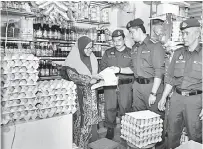  ?? — Gambar Bernama ?? PERIKSA HARGA: Zulfahmy (dua kanan) memeriksa harga telur ayam pada operasi bersepadu bersama sepuluh agensi penguatkua­saan di Pasar Kuala Berang, Hulu Terengganu, semalam