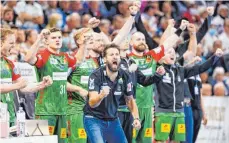  ?? FOTO: FRANK MOLTER/DPA ?? Haben allen Grund zum Jubeln: Magdeburgs Handballtr­ainer Bennet Wiegert (Mi.) und seine Spieler nach dem Coup gegen Kiel.