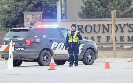  ?? MIKE DE SISTI / MILWAUKEE JOURNAL SENTINEL ?? Police respond to an incident at the Roundy’s Distributi­on Center at 1120 Distributi­on Court in Oconomowoc on Wednesday where two employees were killed.