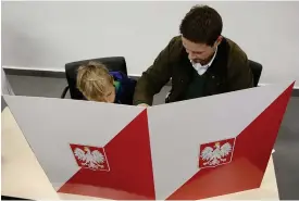  ?? FOTO: TT-AP/CZAREK SOKOLOWSKI ?? PO:s Rafal Trzaskowsk­i blir borgmästar­e i Warszawa. Här röstar han tillsamman­s■ med sin son.