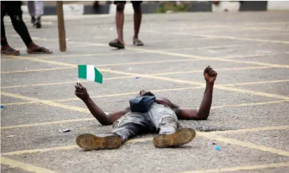  ??  ?? A protester holding the Nigerian flag near the Lagos governor’s office. ‘The #EndSars campaign against police abuses has drawn highprofil­e support around the world, but at home has unleashed more state brutality.’ Photograph: Akintunde Akinleye/EPA