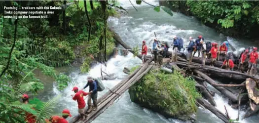  ??  ?? Footslog ... trekkers with the Kokoda Treks company negotiate a river crossing on the famous trail.