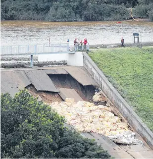  ?? PHIL NOBLE REUTERS ?? Sand bags are seen placed on top of the dam after a nearby reservoir was damaged by flooding, in Whaley Bridge, Britain August 2. •