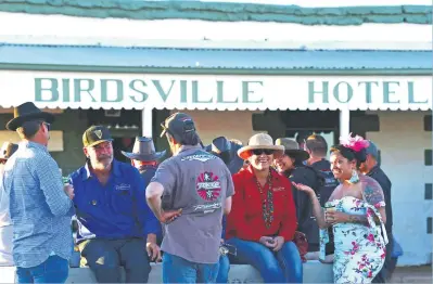  ?? Pictures: AFP ?? ADVENTUROU­S. Racegoers gather in front of the Birdsville Hotel. The annual Birdsville races in outback Queensland attracts thousands of people to the remote town and is a major source of tourist revenue.