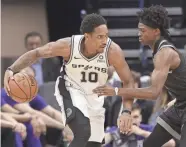  ?? AP ?? San Antonio Spurs guard Demar Derozan, left, works against Sacramento Kings guard De'aaron Fox on Monday in Sacramento.