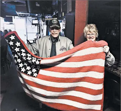  ?? JERRY DAVICH/POST-TRIBUNE PHOTOS ?? Larry and Ceil McCormick, of Hobart, unfurl her surprise gift to him at their favorite bar, Red Carpet Lounge in Portage.