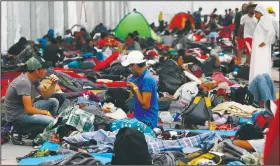  ?? AP/MARCO UGARTE ?? Central American migrants rest Tuesday in the shelter of the Jesus Martinez stadium in Mexico City.