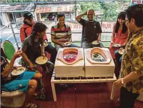  ?? [ FOTO AFP ] ?? Pelanggan sedang menjamu selera di Semarang. di kafe unik yang terletak