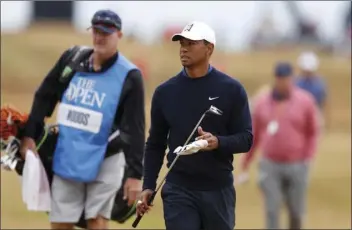  ?? PHOTO/ALASTAIR GRANT ?? Tiger Woods of the United States walks the third holes during a practice round for the 147th British Open Golf championsh­ips in Carnoustie, Scotland, on Tuesday. The Open Golf championsh­ips starts Thursday. AP