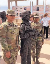  ??  ?? After the dedication ceremony for the new monument, Rosemary Montoya and Mikah Henry with the Army National Reserve take photos with some of the statues.