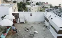  ??  ?? Syrian national Salah Sido Rcho smokes a waterpipe as he observes his pigeons on the rooftop of his building.