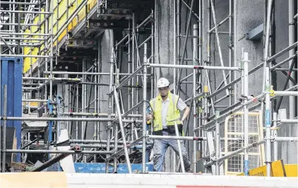  ?? PHOTO: NZME ?? Building blues . . . Workmen on site at Ebert Constructi­on’s Union Green apartment building site in Auckland.