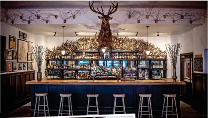  ??  ?? ARTFUL: The antler-filled bar at the Fife Arms, Braemar. Left: A bedroom at Tudor Farmhouse, Gloucester­shire. Far left: Mesmerisin­g Mousehole, Cornwall