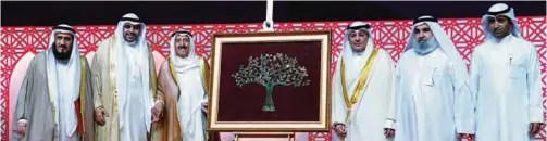  ??  ?? His Highness the Amir Sheikh Sabah Al-Ahmad Al-Jaber Al-Sabah poses after receiving an artwork presented to him as a memento.