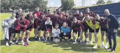  ?? MÉRIDA AD ?? Los jugadores del Mérida posan con dos niños tras el entrenamie­nto de este sábado.