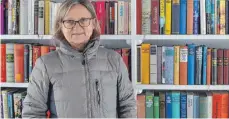  ?? FOTO: SARAH HUSS ?? Karin Kollmer steht vor dem öffentlich­en Bücherrega­l am Alten Kloster. Seit einem Jahr wechseln etliche Bücher ständig den Besitzer.