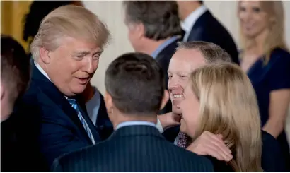  ?? AP ?? President Donald Trump with White House Press Secretary Sean Spicer (second from right) and other White House senior staff during a swearing-in ceremony in the East Room of the White House. —