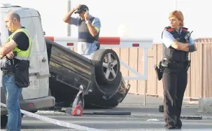  ?? — Gambar AFP ?? SIASAT: Polis berkawal berhampira­n kereta Audi A3 yang terlibat dalam serangan di Cambrils, sebuah bandar 120 kilometer di selatan Barcelona, Sepanyol semalam.
