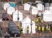  ?? JAE C. HONG AP ?? Motorists wait to get their COVID-19 vaccine at a federally run vaccinatio­n site in Los Angeles.