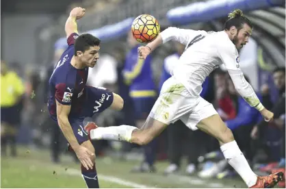  ??  ?? EIBAR: Real Madrid’s Gareth Bale of Wales, right, fights for the ball with SD Eibar’s Ander Capa during their Spanish La Liga soccer match, at Ipurua stadium in Eibar, northern Spain, yesterday. Real Madrid won the match 2-0. — AP